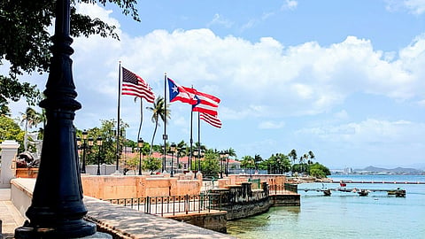 US and Puerto Rico flags by a waterfront.