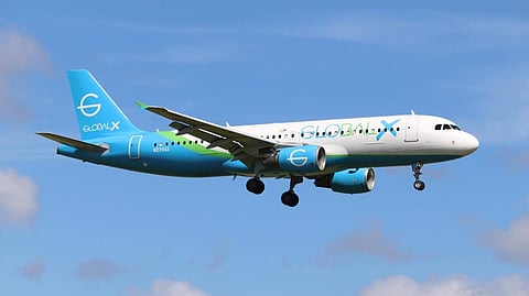 A Global Crossing Airlines Airbus A320 aircraft in flight with landing gear.