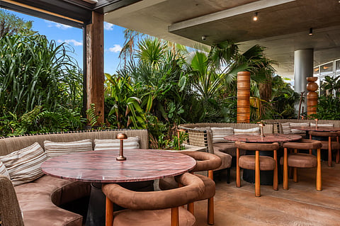 Tropical rooftop terrace with greenery and lounge seating at MILA Miami Beach