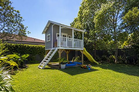Backyard playhouse with a slide.