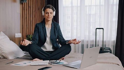 Businesswoman meditating on a bed.