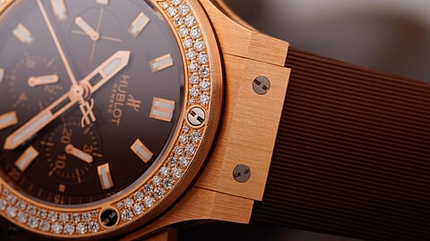 Close-up of a gold Hublot watch with diamonds.
