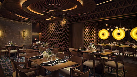 Restaurant dining room with wood tables, latticed walls and circular illuminated ceiling sculpture.