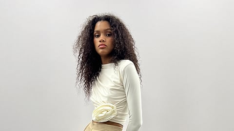 Model in an Efraín Mogollón design posed against a wood wall