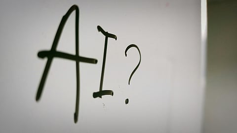 Handwritten "AI?" on a glass board.