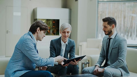 Business professionals reviewing a tablet together.