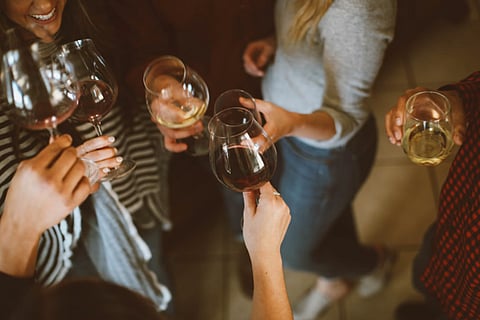 People toasting with wine glasses.