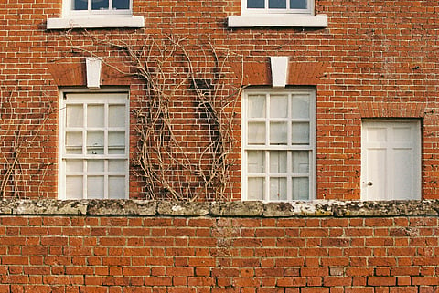 Brick building with white windows and door.