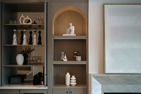 Built-in arched shelving with decorative vases and barware.