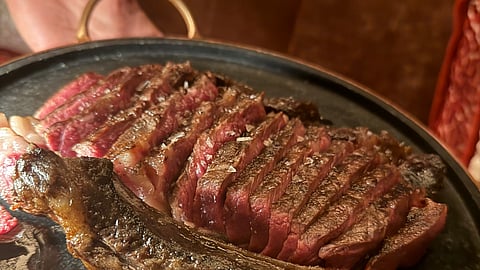 Sliced Akaushi beef rib steak chuletón on a dark platter at Bazaar Meat Miami Beach