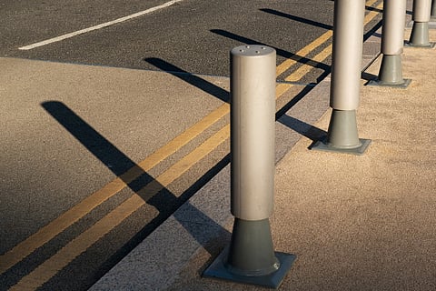 Row of metal bollards along a curb.