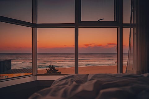 Ocean sunset view through bedroom window.