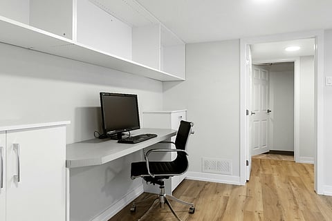 Minimalist home office with a built-in desk and computer.