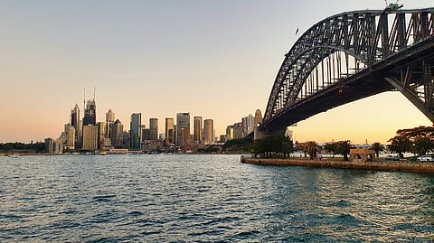 Sydney Harbour Bridge and skyline over water.