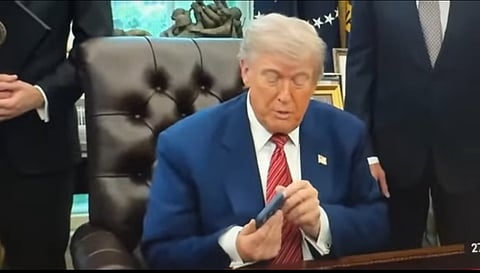 President Trump blir störd av sin telefon.