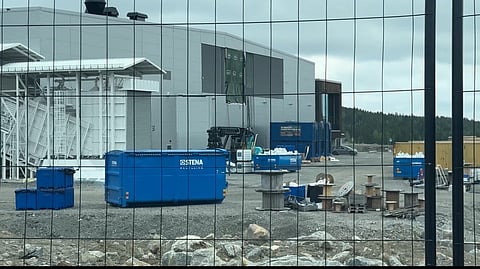 Utanför Revolt hanteras containrar med avfall.