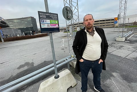 Fredrik Clementz (MED) vid korttidsparkeringen vid Arlanda flygplats terminal 5. Som framgår av informationsskylten bakom honom är parkeringstaxan 100 kr/timme - dyrare än på många parkeringsplatser i Stockholms innerstad.
