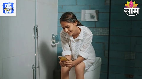 A person using a smartphone while sitting in the toilet, unaware of the germs accumulating on the device