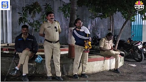 Woman police officer with child on duty in heavy rain during Ajit Pawar’s Beed tour.