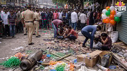 Police and locals gather at the site after a nitrogen gas cylinder used for inflating balloons exploded near a college stop in Malegaon.