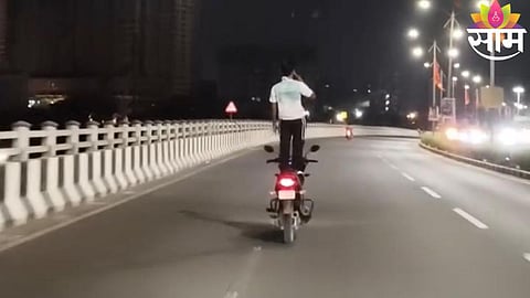 A youth performs a dangerous stunt by standing on a moving bike in Dombivli, raising serious safety concerns.
