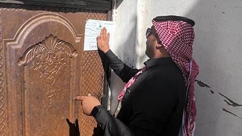 موظف البلدية أثناء تعليق ملصق الإغلاق 