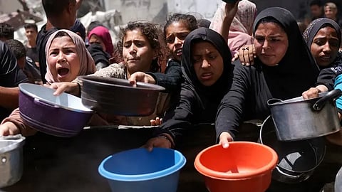 فلسطينيون ينتظرون الطعام من مطبخ خيري في جباليا شمال غزة يوم 19 مايو
