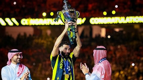 كريم بنزيما لاعب الاتحاد حاملاً كأس بطولة دوري روشن بحضور وزير الرياضة