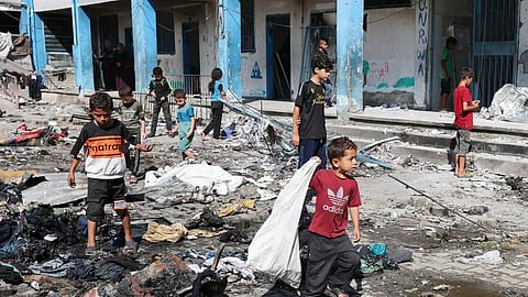 أطفال فلسطينيون بالقرب من موقع غارة إسرائيلية في غزة - 8 يوليو 2025 
