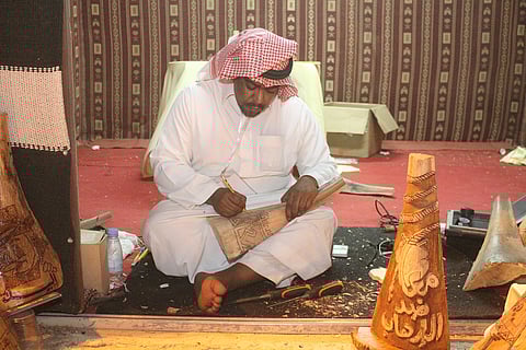 أنامل ذهبية نقشت الأخشاب وزخرفت الخط العربي وخاطت السدو في سوق عكاظ