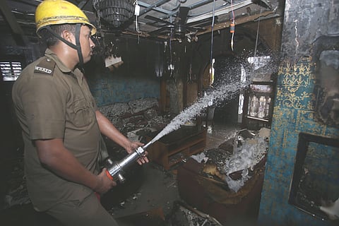 बेहला के फ्लैट में लगी आग को बुझाते हुए दमकल कर्मी