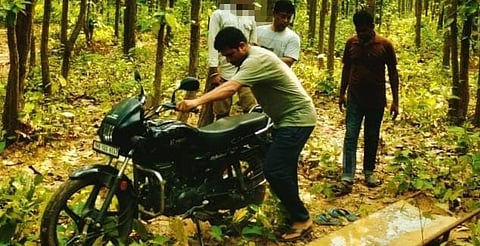 जंगल के अंदर पेड़ से लटकते शव के समीप खड़ी उसी युवक की मोटर साइकिल