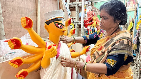 महिला मूर्तिकार चाइना पाल प्रतिमा को अंतिम रूप देती हुईं