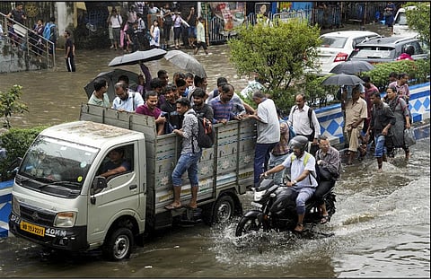 जलजमाव के बीच मेटाडोर में सफर करते ऑफिस जाने वाले यात्री