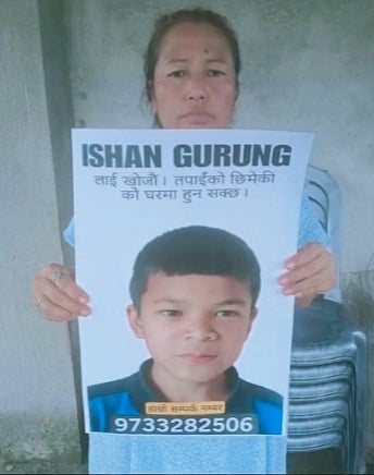 The grieving mother shows the poster of her missing son.
