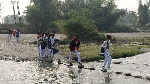 कूर्ती नदी पार कर परीक्षा देने जाते माध्यमिक परीक्षार्थी