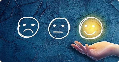 Three faces expressing three emotions, with a focus on the smiling face