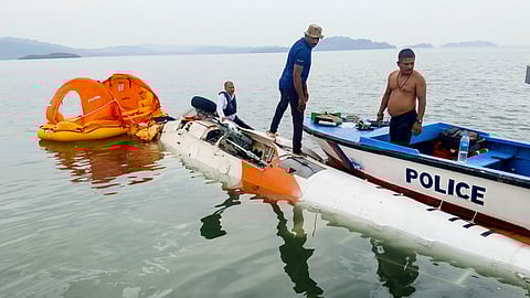 समुद्र में गिरा हेलीकॉप्टर और बचाव कार्य में लगे पुलिसकर्मी।