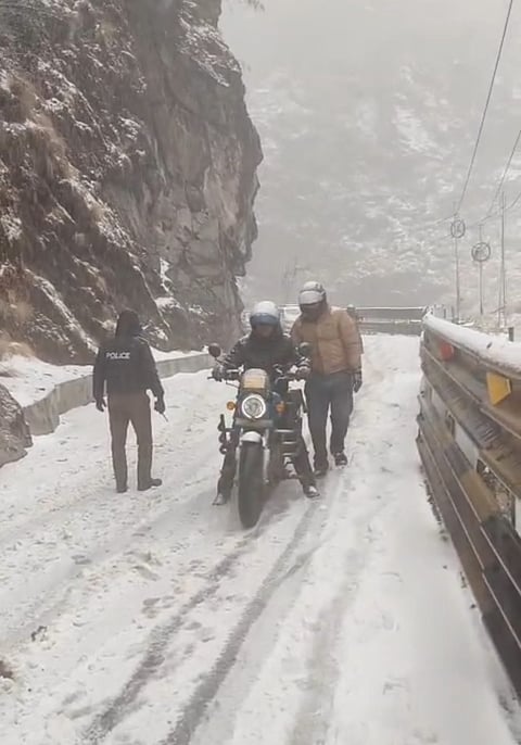 बर्फबारी में आवाजाही करते यात्री

