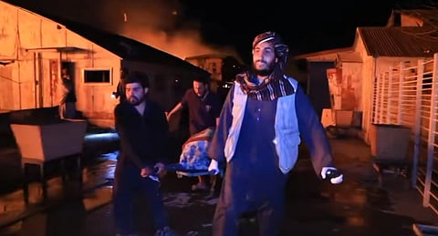 एक घायल व्यक्ति को लेकर जाते लोग।