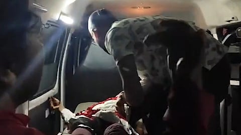 एक बच्ची को एंबुलेंस में रखते हुए। 