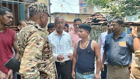 मतदान केंद्र के बाहर मतदाता राकेश साहनी अपनी शिकायत तृणमूल नेता गौतम देव के सामने दर्ज कराते हुए