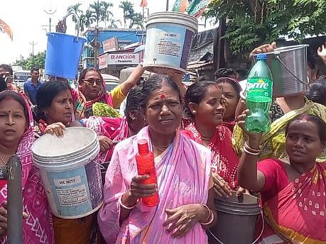 बाल्टी के साथ प्रदर्शन करते लोग 