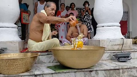 मदन मोहन देव को स्नान कराते पुरोहित
