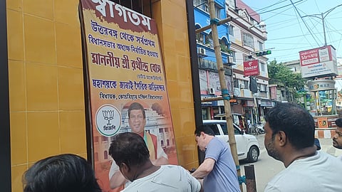 पोस्टर हटाते भाजपा जिला उपाध्यक्ष बिराज बोस अन्य कार्यकर्ता
