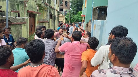 तृणमूल नेता की पिटाई करते स्थानीय लोग 