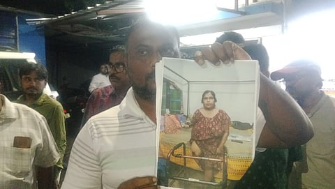 पैर गंवानी वाली महिला मालती विश्वास की तस्वीर दिखाता हुआ एक व्यक्ति 