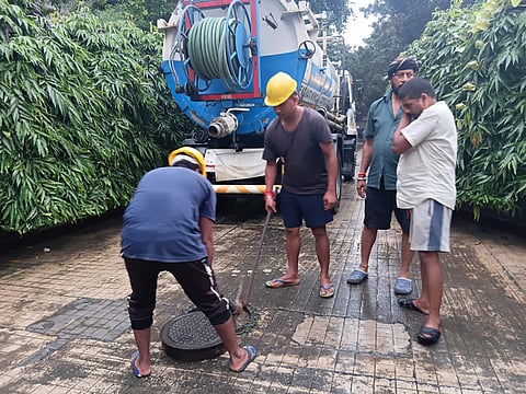 नगर निगम के कर्मी बारिश का पानी निकालते हुए