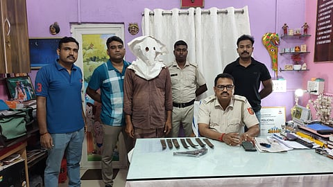 गिरफ्तार अभियुक्त को पुलिस अधिकारी दिखाते हुए 