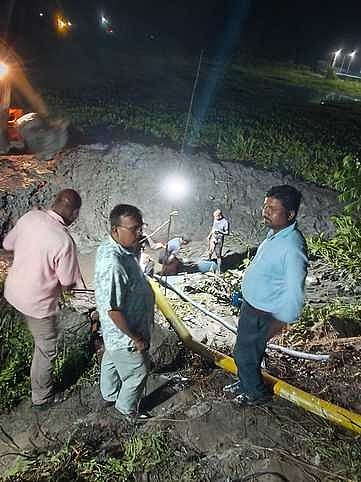 क्षतिग्रस्त पाइप की मरम्मत करते कर्मचारी